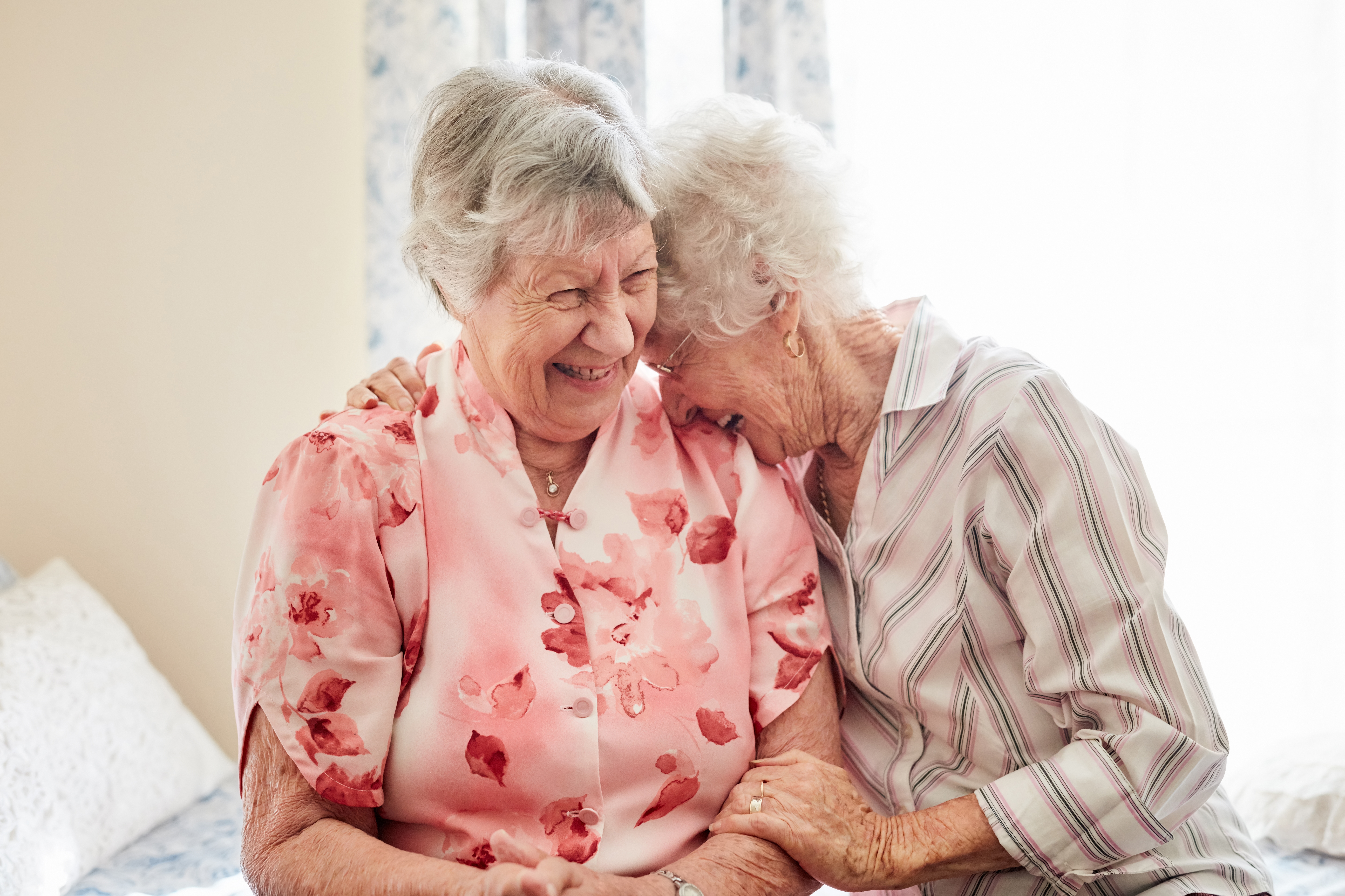 “Sharing a laugh, sharing support: Two senior women demonstrate the emotional connection and sense of community fostered by respite care.”